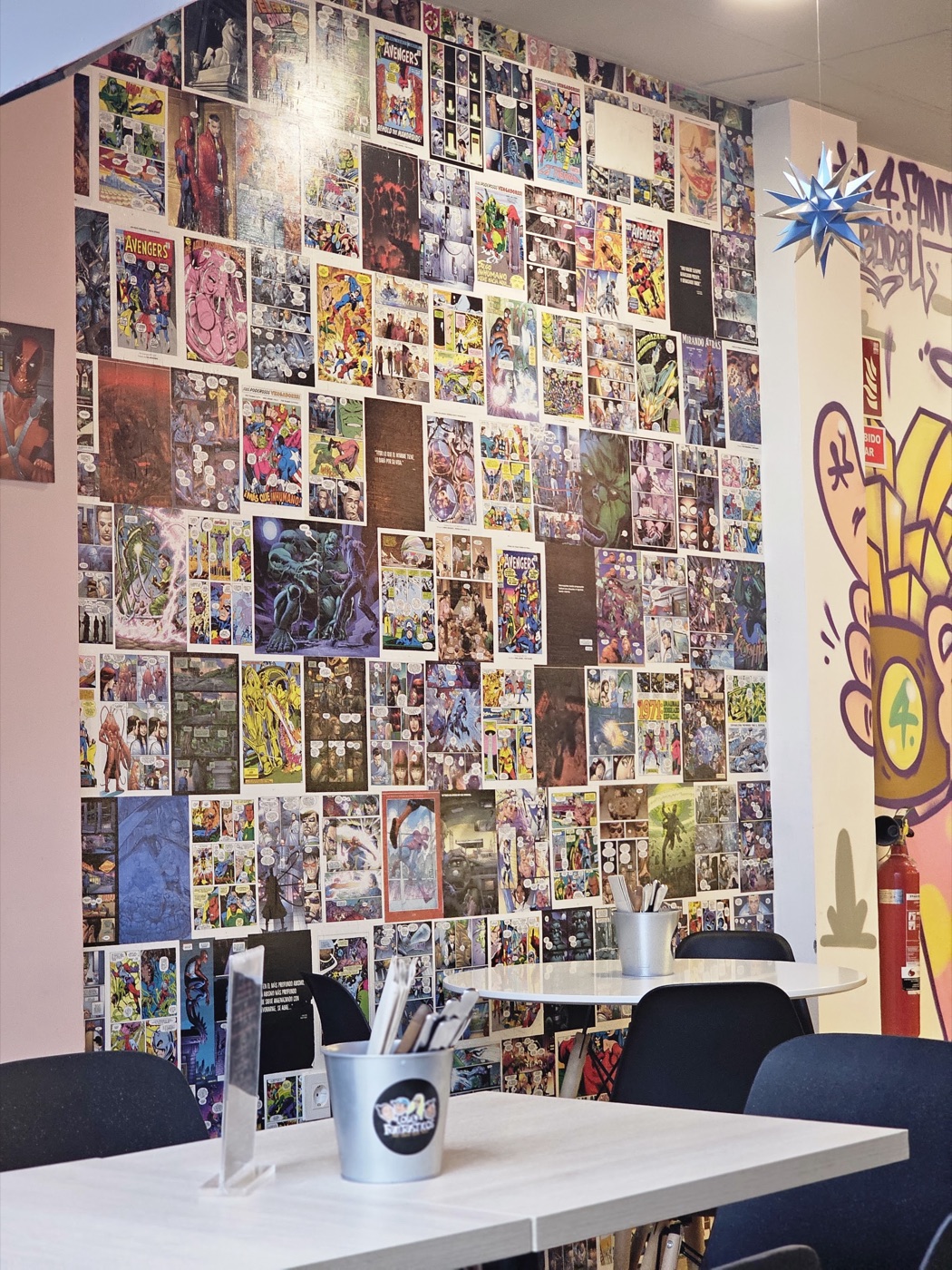 Pared de portadas de cómic junto al mural